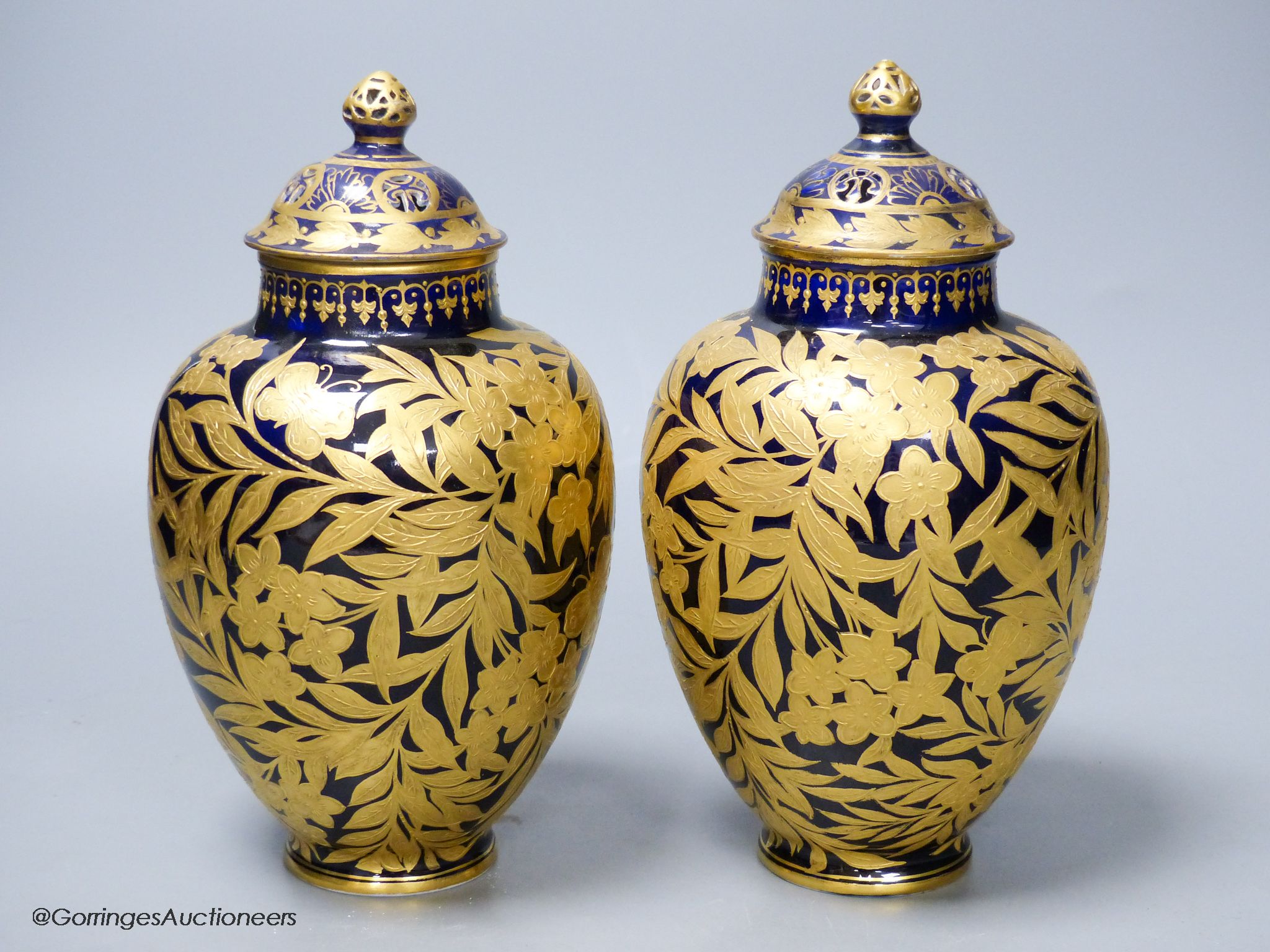 A pair of Crown Derby blue and gilt vases, both with restored lids, height 21cm